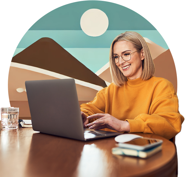 A woman sitting at a table with a laptop.